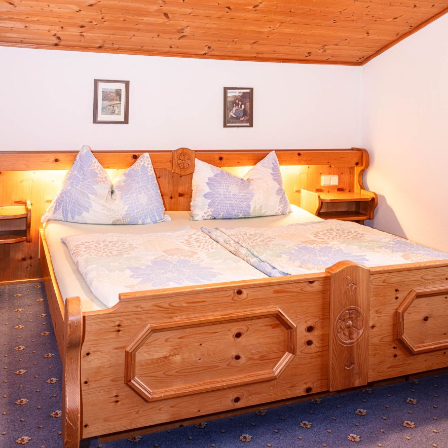 Doppelzimmer mit Holzbett in der Ski & Paw Lodge